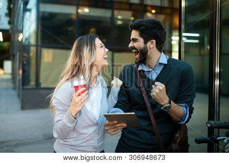 Excited Young Couple Watching Content In A Tablet Outdoo