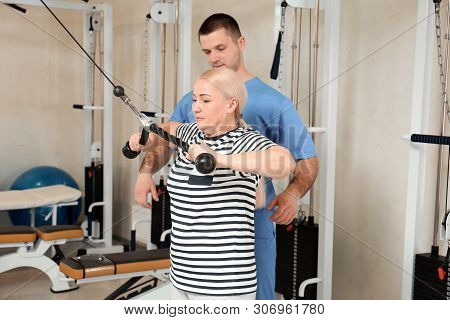 Patient Exercising Under Physiotherapist Supervision In Rehabilitation Center