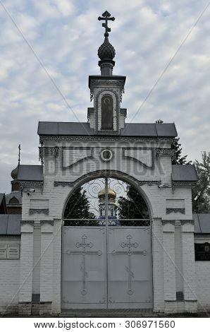 The Entrance Gate In The Orthodox Church Of The Holy Spirit Courtyard, Russia. Blue Sky And White Cl
