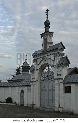 The Entrance Gate In The Orthodox Church Of The Holy Spirit Courtyard, Russia. Blue Sky And White Cl