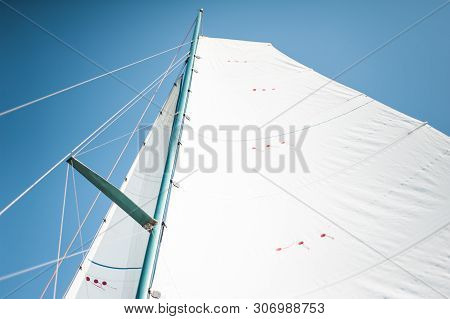 White Cloth Fabric, Masts And Ropes Close-up On The Sail Of Tri-yacht Or Yacht Sailing Boat