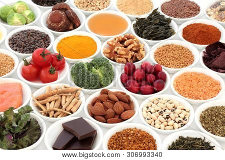 Health food to slow ageing process concept including fruit, vegetables, seeds, nuts, herbs, honey, pollen grain and dark chocolate. Very high in antioxidants, anthocyanins, dietary fibre and vitamins.
