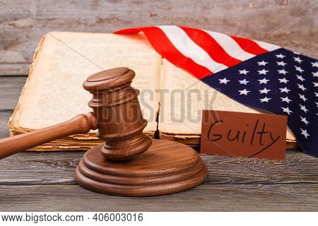 Concept Of Guilty Verdict In The Usa Court. Wooden Judge Hammer With Olw Worn Law Book And American 