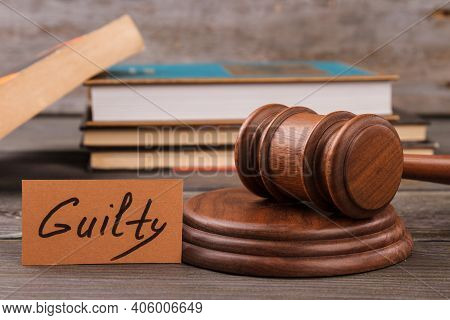 Gudge Gavel And Guilty Verdict. Stack Of Books On The Background.
