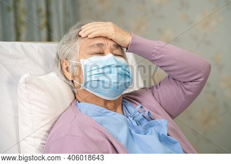Asian Senior Or Elderly Old Lady Woman Patient Wearing A Face Mask And Headache New Normal In Hospit