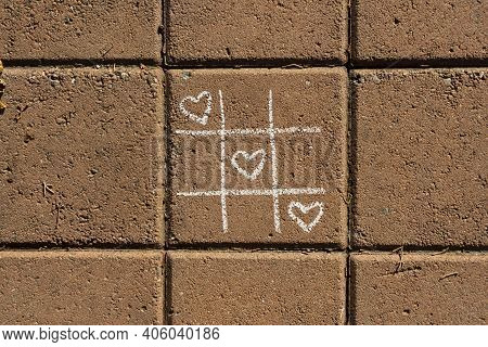 Tic Tac Toe Game With Chalk Heart Drawings On Sidewalk