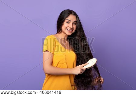 Hair Care And Beauty Concept. Portrait Of Smiling Beautiful Young Indian Woman Brushing Her Natural 