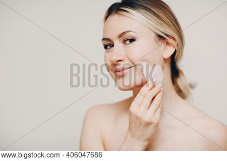 Young Adult Woman Doing Face Guasha Treatment Massage
