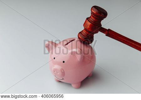 Judge Gavel And Piggy Bank On A White Table.