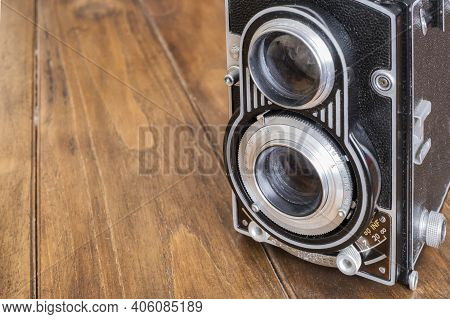 Detail Of The Lenses Of An Old Twin Lens Reflex Camera, On A Wooden Table, Antique And Classic Photo