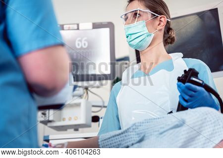 Internal specialist doctor operating endoscope in colonoscopy procedure