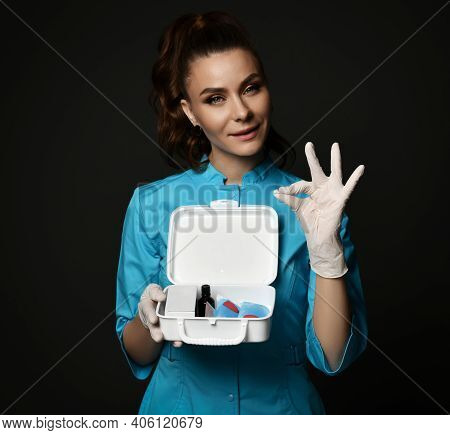 Young Woman Doctor Nurse In Blue Uniform And Protective Latex Gloves Holding First Aid Kit In Hands 