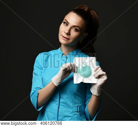 Young Woman Doctor Nurse In Blue Uniform And Protective Latex Gloves Demonstrates Special Medical To