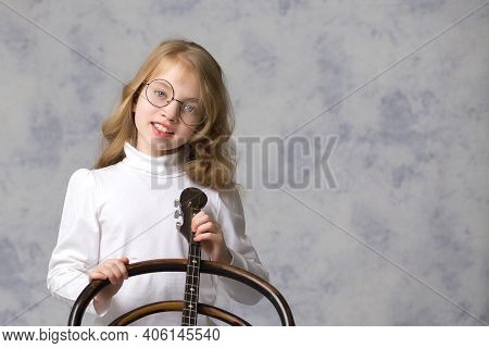 Cute Little Girl Learning To Play The Plucked Musical Instrument, Domra.