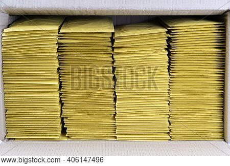Four Stacks Of Yellow Mailing Envelopes In A Shipping Box