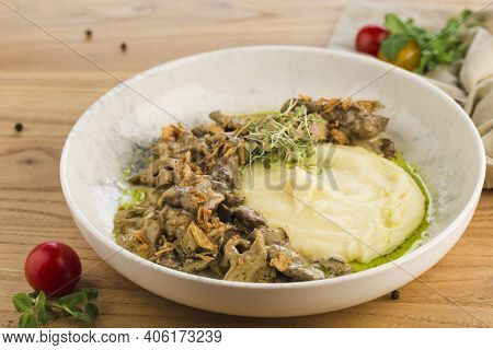 Beef Stroganoff With Mashed Potatoes In A Plate On A Light Wooden Background. Restaurant Food From T