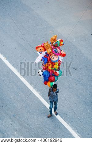 PATAN, NEPAL - 19 APRIL, 2018: Young Nepalese man selling balloons during Rato Machindranath chariot procession.
