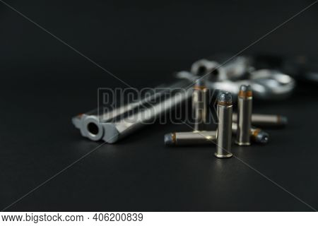 357 Caliber Hollow Point Bullets Near Revolver Pistol Gun On Black Background