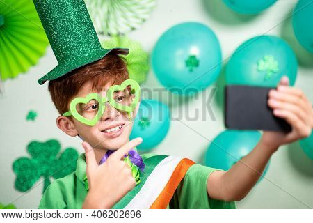 Young Kid On Video Call During Saint Patricks Day Celebration On Mobile Phone And Showing Decorated 
