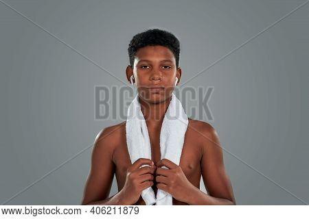 After Workout. Half Naked Teenage African Boy With Towel On Shoulders Looking At Camera, Standing Ag