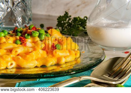 Macaroni And Cheese With Green Peas And Crushed Red Pepper On Bright Sunny Day