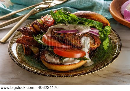 Greek Stuffed Turkey Burger Topped With Cucumber Slices And Tzatziki Yogurt Sauce Served With Medite