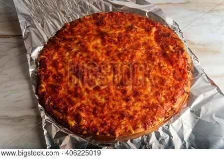 Unsliced Crispy Nyc Style Pizza Pie On Tin Foil