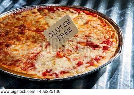 Gluten Free New York Style Pizza Pie Served On Disposable Cooking Tin With Ribbed Metal Panel Backgr