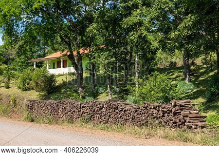 Small House With Vegetation Around And Wood Pile, Linha Nova Village, Rio Grande Do Sul, Brazil