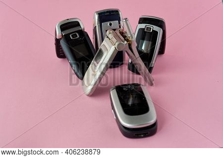 Broken Mobile Phones, Recycling Technology, Early 2000S On Pink Background And Copy Space,