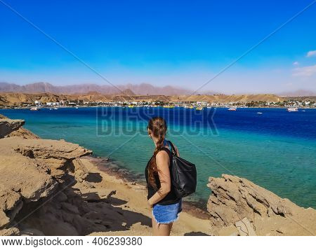 A Young Woman Stands On A Rock And Looks At The Opposite Side Of The Sharm El-maya Bay In Sharm El S