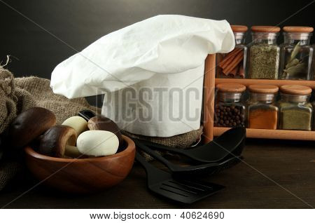 Sammansättning med kockens hatt och kitchenwear på bordet på grå bakgrund