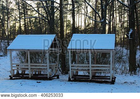 Two Wooden Gazebos For Winter Recreation In The Winter Forest. Wooden Canopy With Benches In The Sno