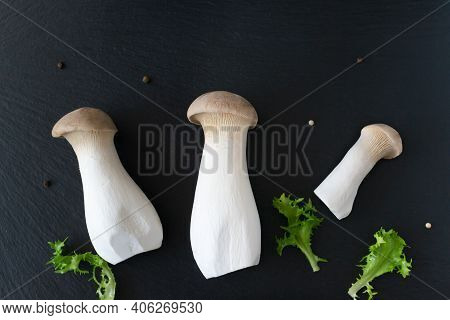 Eringi Mushrooms With Herbs On A Black Background. Pleurotus Eringi. Vegan Food Concept. Flatlay.