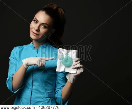 Young Woman Doctor Nurse In Blue Uniform And Protective Latex Gloves Shows Points Finger At Special 