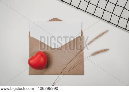 Blank White Paper Is Placed On Open Brown Paper Envelope With Red Heart, Bristly Foxtail Dry Flower,