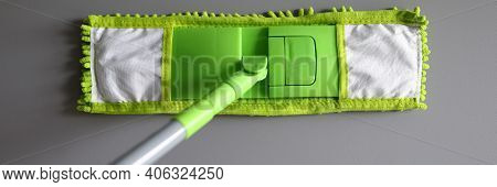 Top View Of Green Mop With Handle For Floor Cleaning. Macro Shot Of Fluffy Rag. Equipment Of Profess