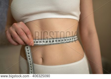 Close Up Photo Of Healthy Woman With Slim Belly Measuring Her Waists Size
