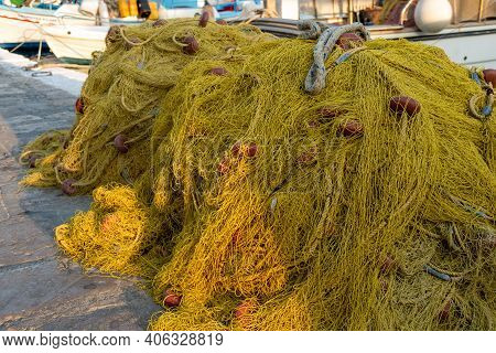 Collorful Yellow And Orange Traditional Fisshing Nets In A Harbor With A Boat On The Background. Lay