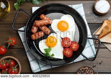 Romantic Breakfast With Fried Sausages And Heart Shaped Eggs On Wooden Table, Flat Lay. Valentine's 