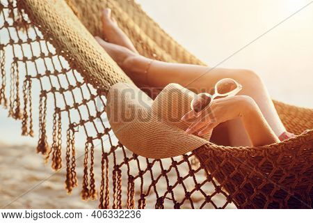 Vacation Beach Summer Holiday Concept. Feet And Hand Relaxing Woman In Hammock On The Beach During S