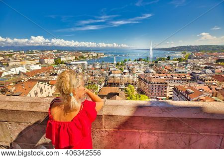 Back View Of Woman Tourist Looking Geneva Skyline, Jet Deau Fountain, Lake Leman, Bay And Harbor Fro