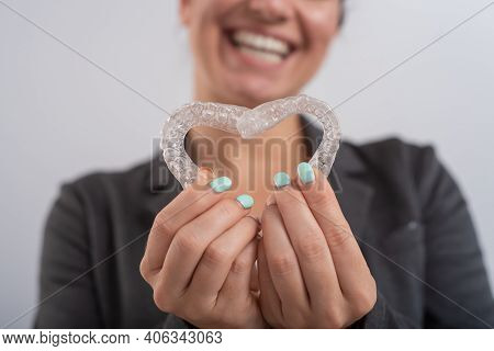 Caucasian Woman Holding Two Transparent Heart-shaped Aligners