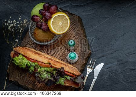A Delicious Smoked Salmon Sesame Bread Sandwich With Fresh Fruit On A Wooden Plate. It Is Perfect Ea