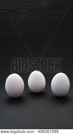 Boiled Or Raw Chicken Eggs On A Black Background. Healthy Balanced Eating With Tar Rolls.