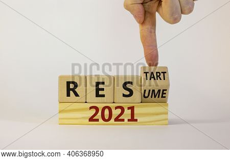 2021 Resume And Restart Symbol. Businessman Turns A Cube And Changes The Word '2021 Resume' To '2021