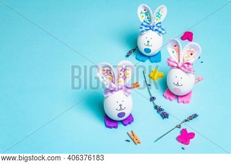 Traditional Easter Symbols Concept. Cute Rabbits From Eggs, Wicker Wreath With Flowers, Fragrant Lav