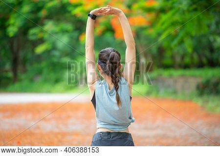Back View Of Runner Woman Doing Stretching And Warming Up Her Body Before Running. The Benifit Of St