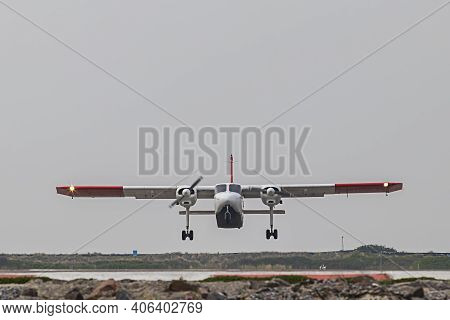 A Small Plane Takes Off And Takes Off On The Island Of Dune. Background Is Bright Sky