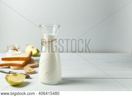 Fermented Drink, Kefir, Natural Yogurt In A Glass Carafe. On A Light Wooden Background, With Space